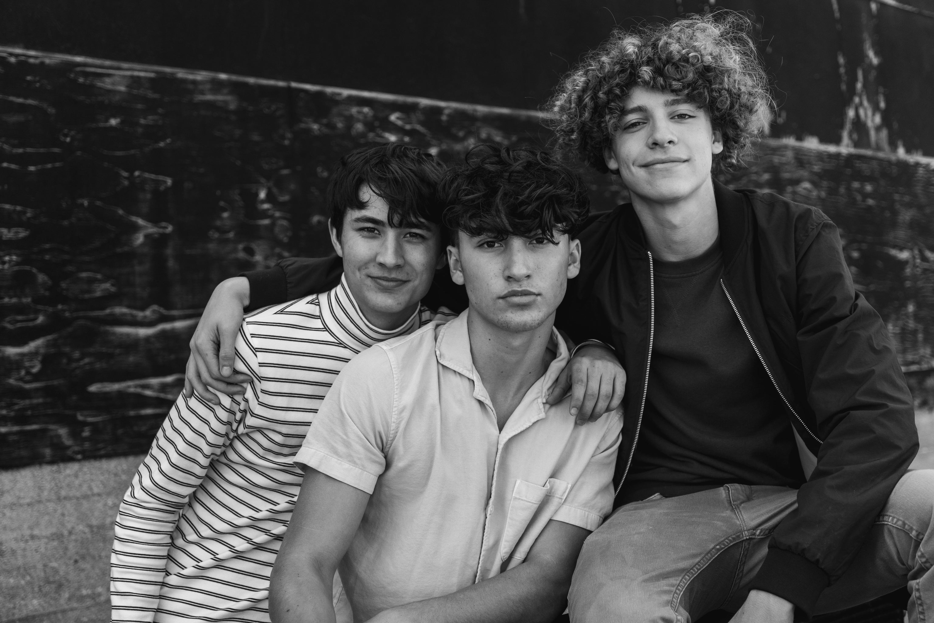 Black and white closeup photo of 3 teenage boys highlighting their skin and faces for a blog post about teenage acne and how to get confidence back.